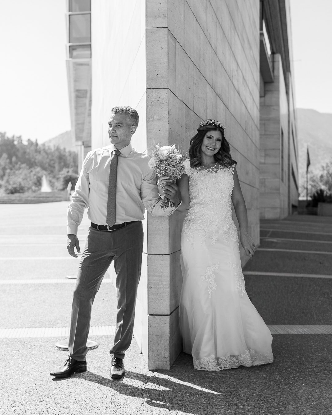 Novios apoyados en un muro